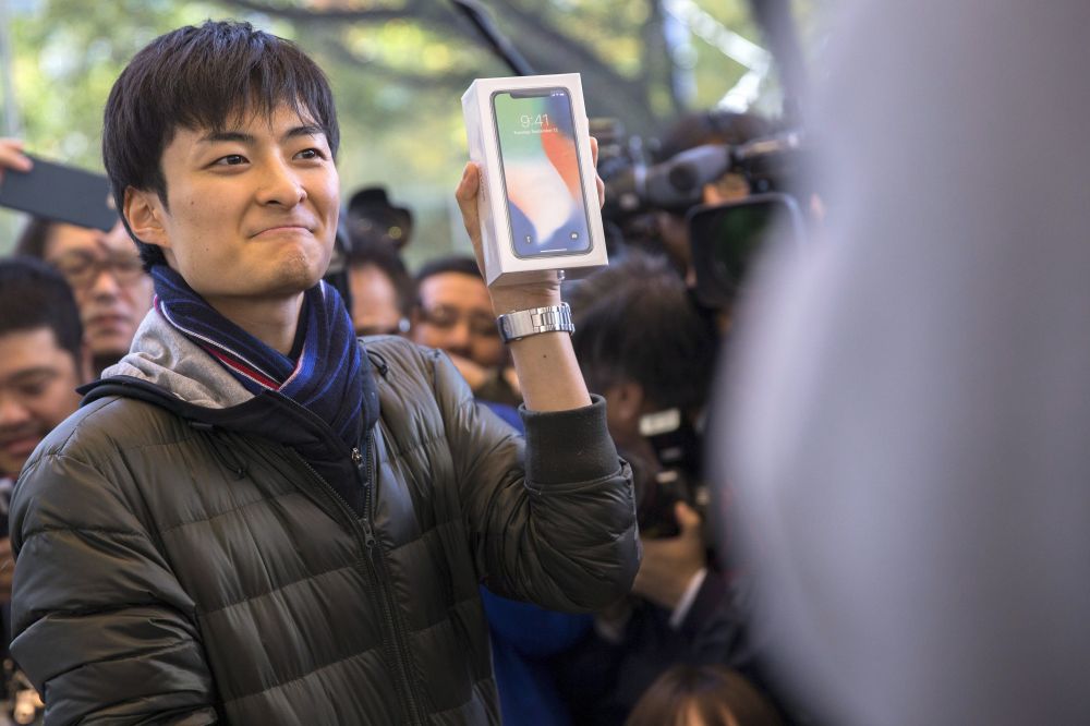 Egy vásárló mutatja az új telefonját Tokióban
