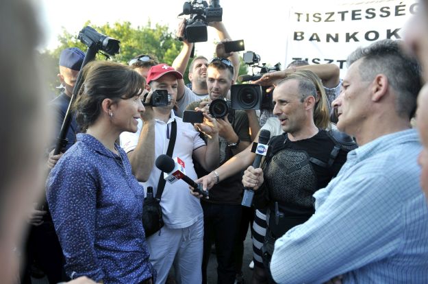 Lévai Anikó tüntetőkkel beszélget a miniszterelnök háza előtt