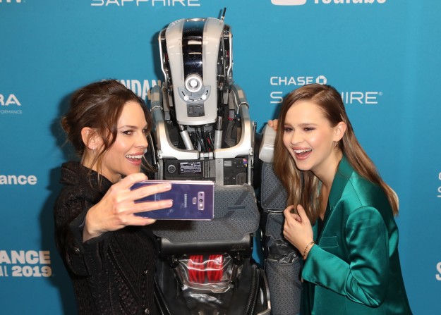 Hilary Swank és Clara Rugaard szelfit készít az Anya nevű robottal az I Am Mother című filmjük bemutatója előtt a Sundance Filmfesztiválon