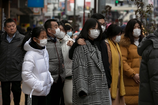 Védőmaszkot viselő gyalogosok Tokió Sindzsuku nevű városrészében 2020. január 27-én. 