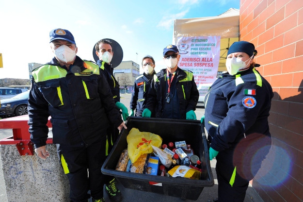 Olasz polgári védelmi önkéntesek a leginkább nélkülözők számára állítanak össze élelmiszercsomagot az észak-olaszországi Buccinascóban a koronavírus-járvány ide