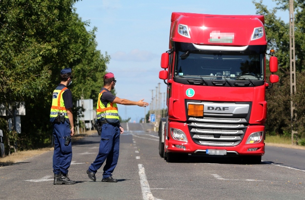 A rendőrök egy kamiont készülnek ellenőrizni a magyar-szlovák határon, a bánrévei határátkelőn 2020. szeptember 8-án.