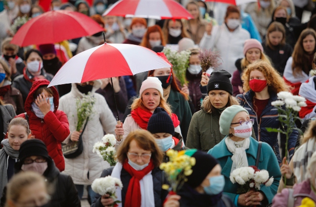 Esernyőt tartó nők tüntetnek az elnökválasztás eredménye ellen Minszkben 2020. október 24-én. 