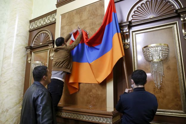 Az örmény parlament jereváni épületébe behatolt tüntetők az ülésterem falára függesztik nemzeti színű zászlót 2020. november 10-én