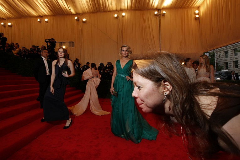 A publicist ducks in front of the camera as celebrities arrive at the Metropolitan Museum of Art Costume Institute Benefit in New York, May 7, 2012.